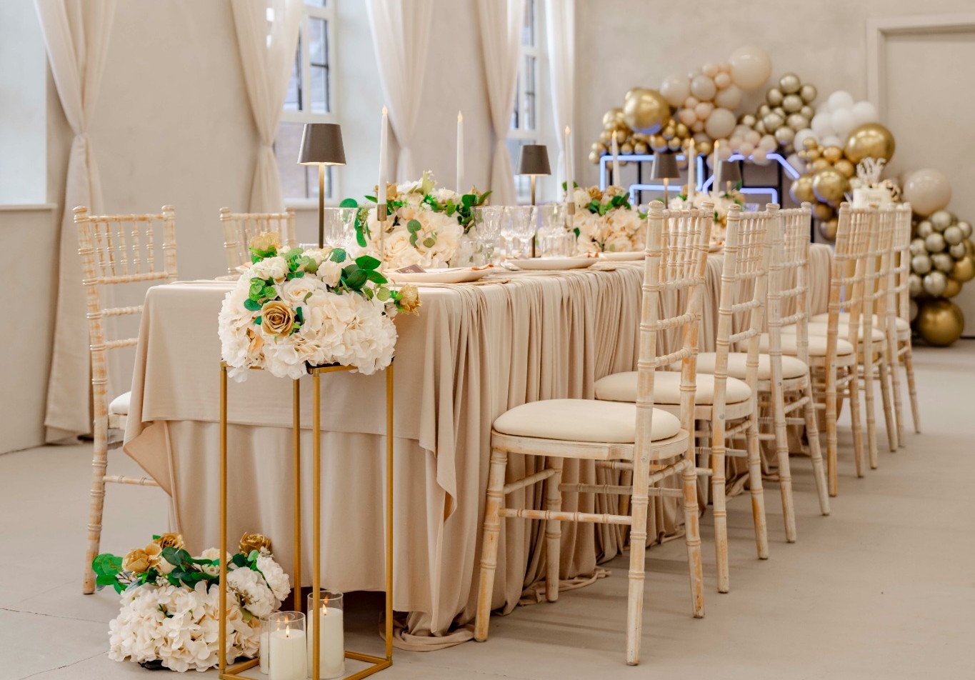The Sanctuary arranged for a birthday dinner, with cream chairs, floral table decorations and gold balloons
